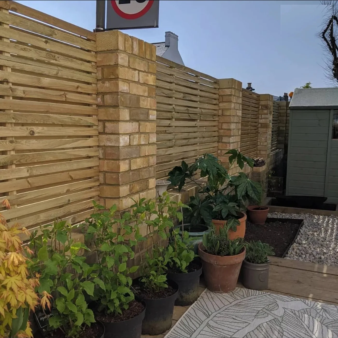 Bespoke made slatted timber fence panels set between extended brick piers in Petts Wood
