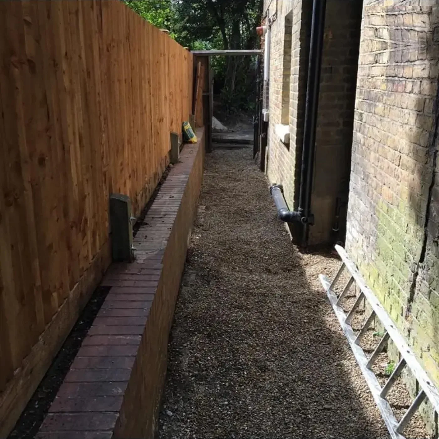 Close board fence with a brick edged path forming a new boundary to a side alleyway in West Wickham